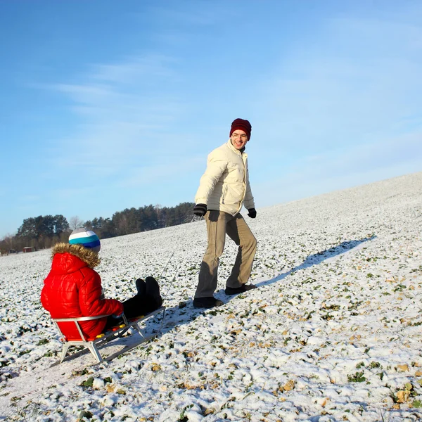 Dad pulling child on sled — Stock Photo, Image