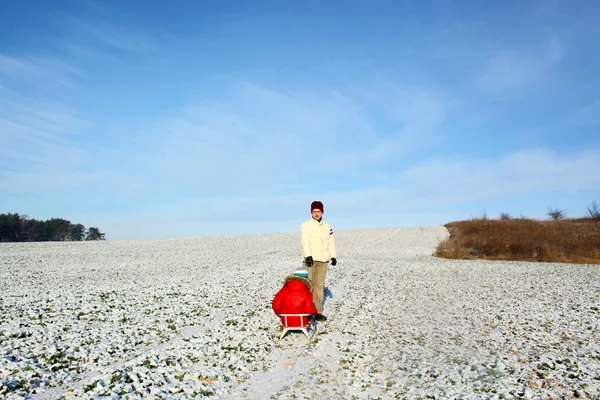 Dad pulling child on sled — Stock Photo, Image