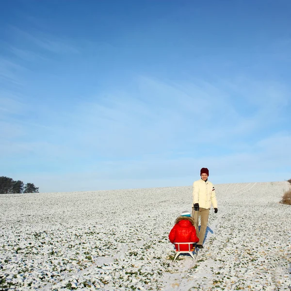 Dad pulling child on sled — Stock Photo, Image