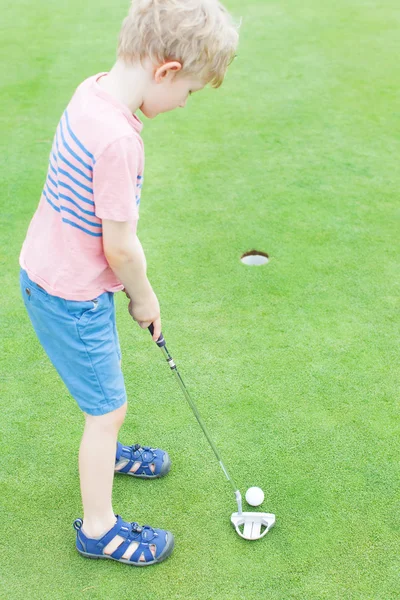 Jongen golfen Stockafbeelding