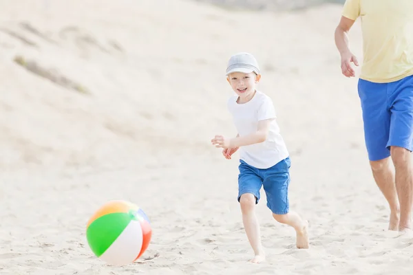 Familie spelen met de bal op het strand — Stockfoto