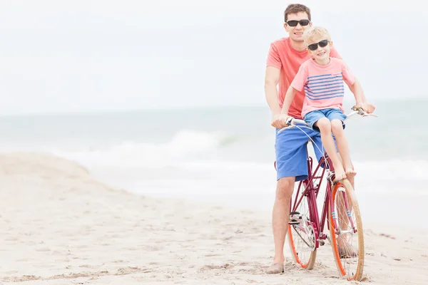 Famiglia in bicicletta in spiaggia — Foto Stock