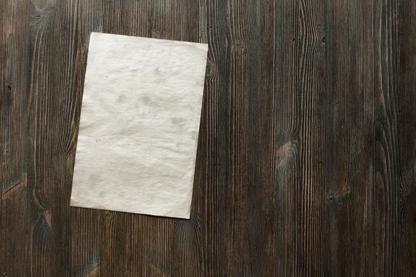 Белая бумага на деревянном фоне — стоковое фото
