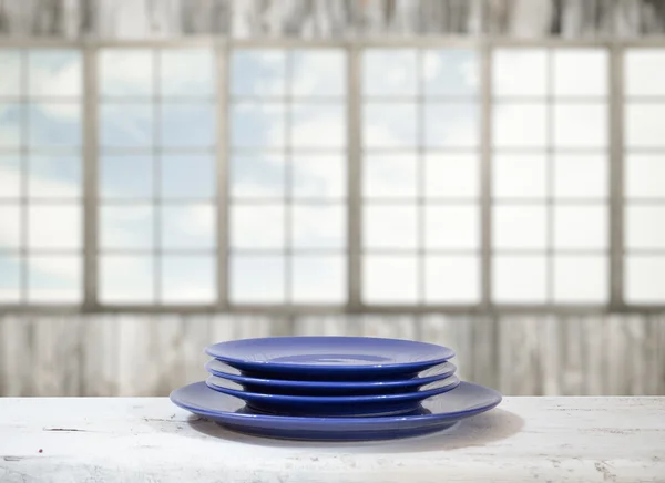 Тарелки на белом столе — стоковое фото