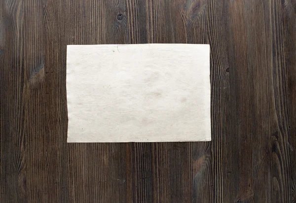 White paper on wooden background — Stock Photo, Image