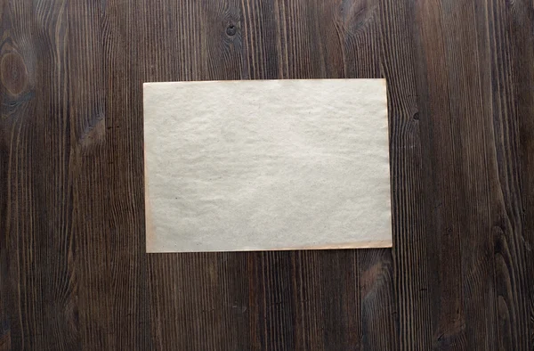 Бумага на деревянном фоне — стоковое фото