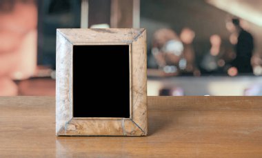 Bir gece kulübündeki ahşap masanın üzerindeki eski fotoğraf çerçevesi.