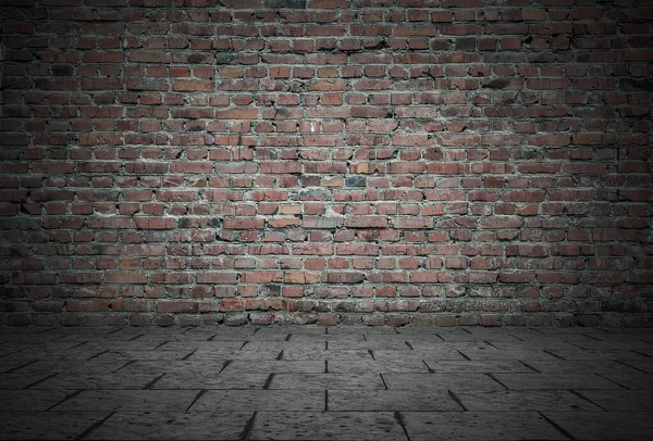 Empty room with bricks wall and tiled floor. Dark background.