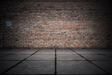 Duvarı tuğlalı ve döşemesi fayanslı boş bir oda. Koyu arkaplan.