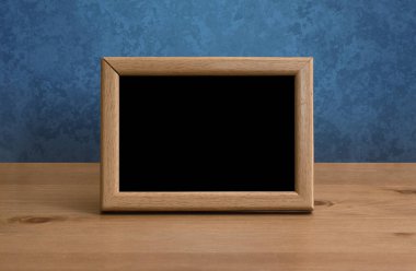 Masada ahşap fotoğraf çerçevesi, mavi duvar.