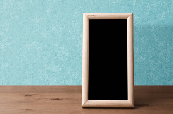 wooden photo frame on table, blue wall