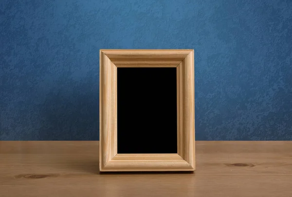 木製のテーブルの上の写真フレーム青い壁 — ストック写真