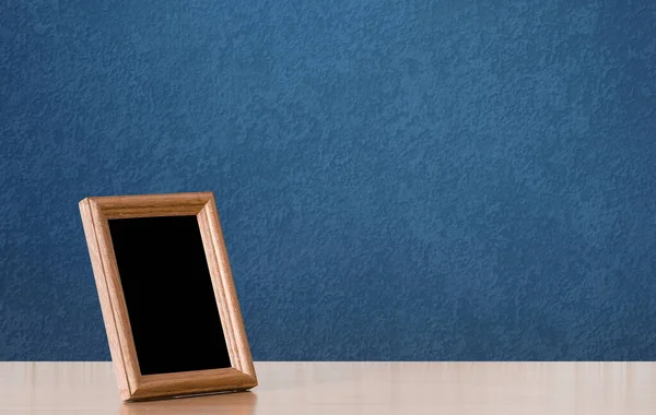 桌子上的木制相框 蓝色墙壁 — 图库照片