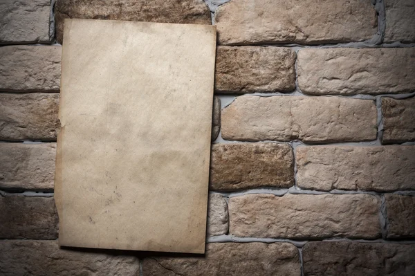 Старая бумага на кирпичной стене — стоковое фото