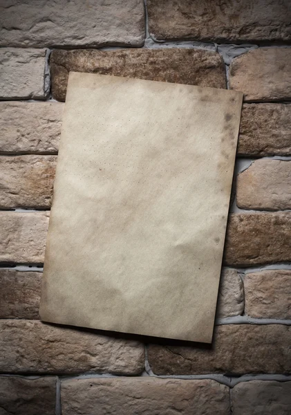 Papel velho na parede de tijolo — Fotografia de Stock