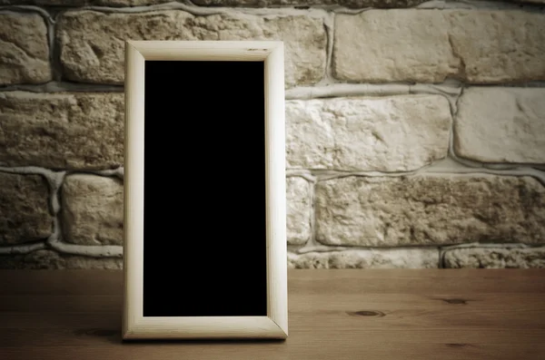 Old photo frame on wooden table — Stock Photo, Image