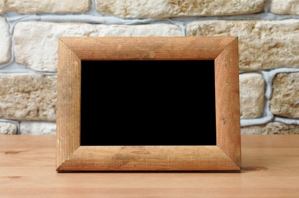 Old photo frame on wooden table — Stock Photo, Image