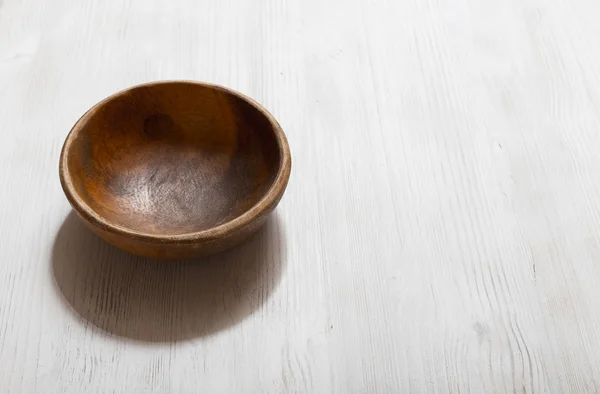 Wooden bowl on white table — Stock Photo, Image