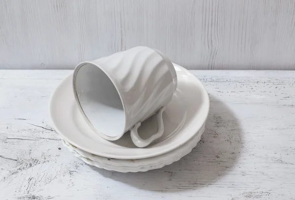 Stack of white plates and cup on table — Stock Photo, Image