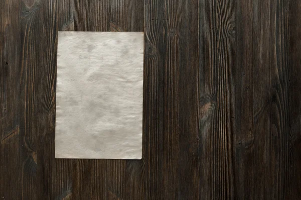 Бумага на старой деревянной поверхности — стоковое фото