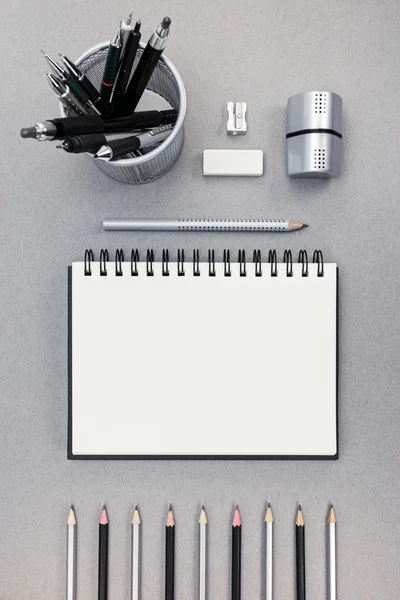 office desk with notepad, pencils, eraser and sharpener