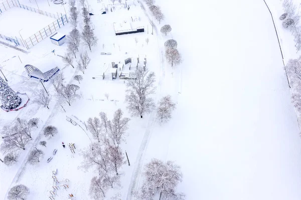 empty outdoor sports ground in winter park covered with snow. aerial photography with drone