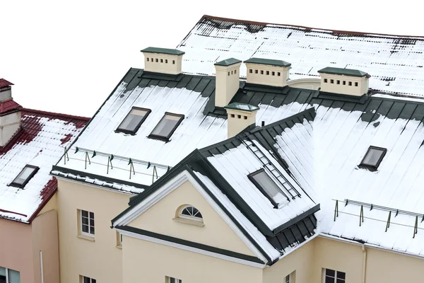 snow covered house roof with skylights