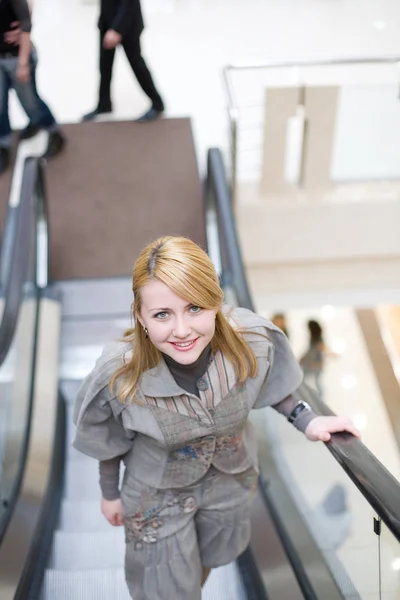 Jolie fille debout sur l'escalator et se déplacer vers le haut — Photo