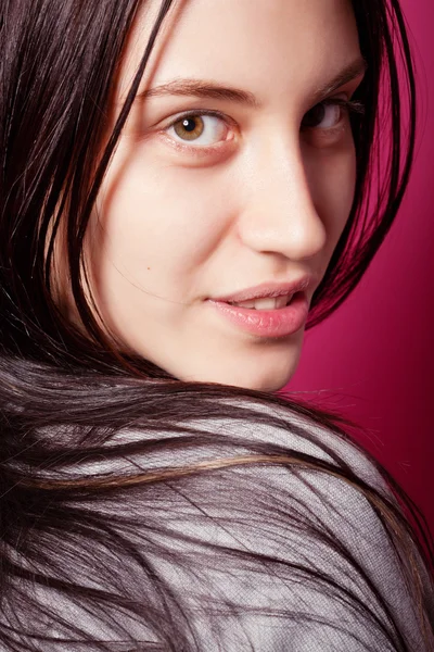 Portrait of attractive brunette girl with long hair over pink — Stock Photo, Image