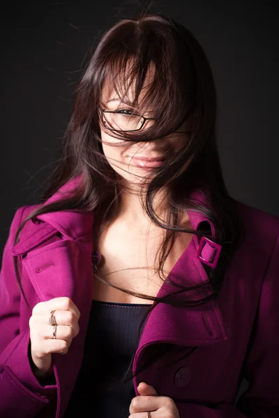 Brunette woman dress pink coat under the high wind — Stock Photo, Image