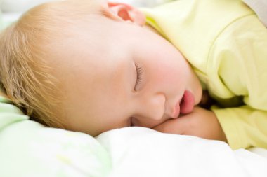 Yatakta uyuyan erkek dinlendirici bebek