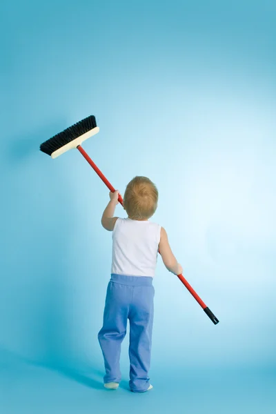 Niño pequeño con hisopo de limpieza sobre azul — Foto de Stock