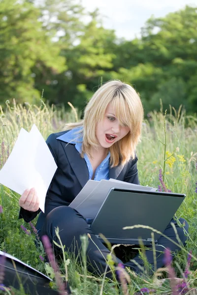 Geweldige zakenvrouw op gras met laptop en documenten — Stockfoto