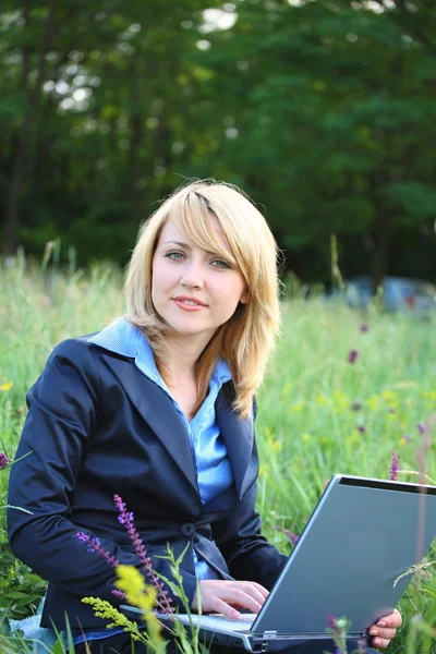 Zakenvrouw op gras met laptop — Stockfoto