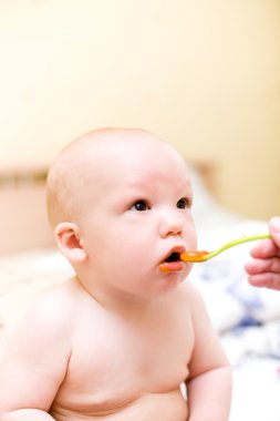 Tarafından plastik kaşık yiyen bebek