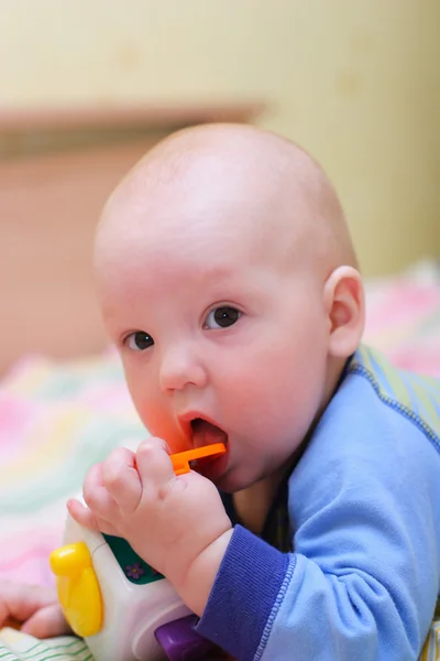 Младенец положил игрушку в рот — стоковое фото
