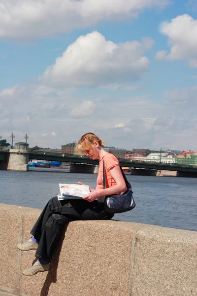 Girl reading magazine on canal border in Saint Petersburg — Stock Photo, Image