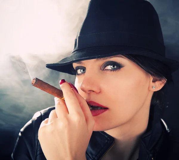 एक महसूस टोपी में आकर्षक ब्रुनेट एक क्यूबा सिगार धूम्रपान — स्टॉक फ़ोटो, इमेज