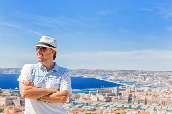 Hombre con sombrero y gafas de sol posando contra la ciudad de Marsella —  Fotos de Stock