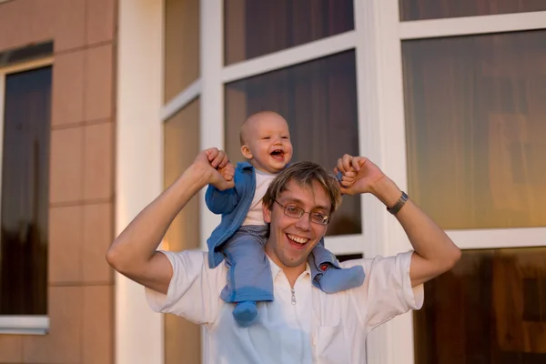 Adorable niño en los hombros de su padre — Foto de Stock