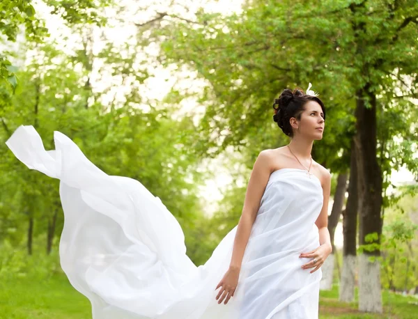 Young white dressed woman walking in spring park Stock Photo