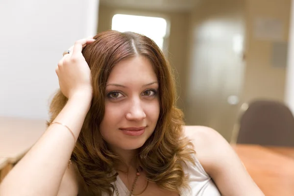 Ładna brunetka uśmiechający się w pomieszczeniu — Zdjęcie stockowe