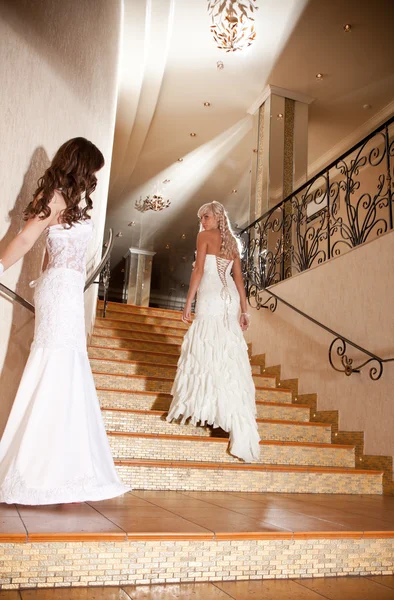 Güzel bir gelinlik merdivenlerde iki kız — Stok fotoğraf