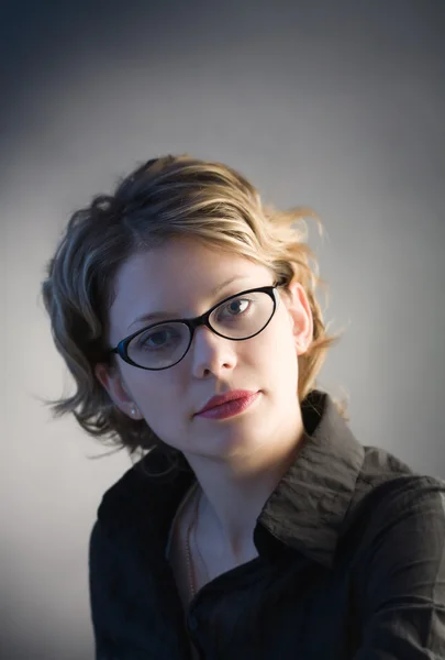 Portrait of pretty woman in glasses over black — Stock Photo, Image