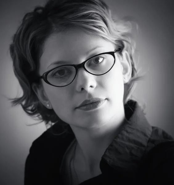 Portrait de jolie femme en lunettes sur noir — Photo