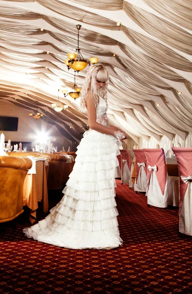 Menina loira bonita em um vestido de noiva posando no restaurante — Fotografia de Stock