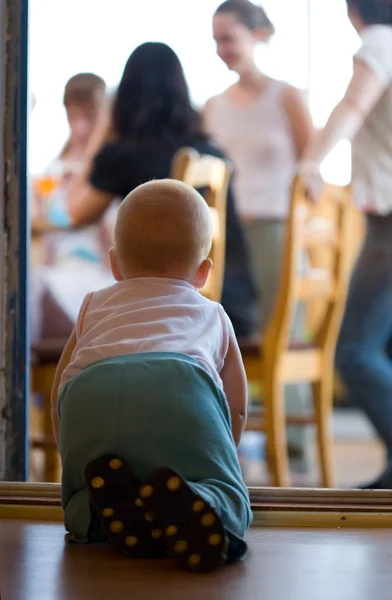 Bayi kecil merangkak melalui celah pintu ke orang tua di teras — Stok Foto