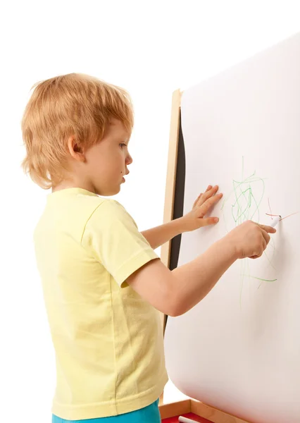 Four-year old boy drawing picture on easel Stock Image