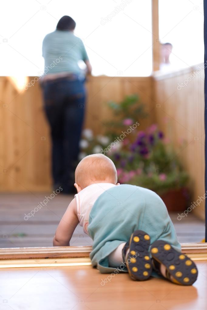 Little baby crawling to his father staying on terrace