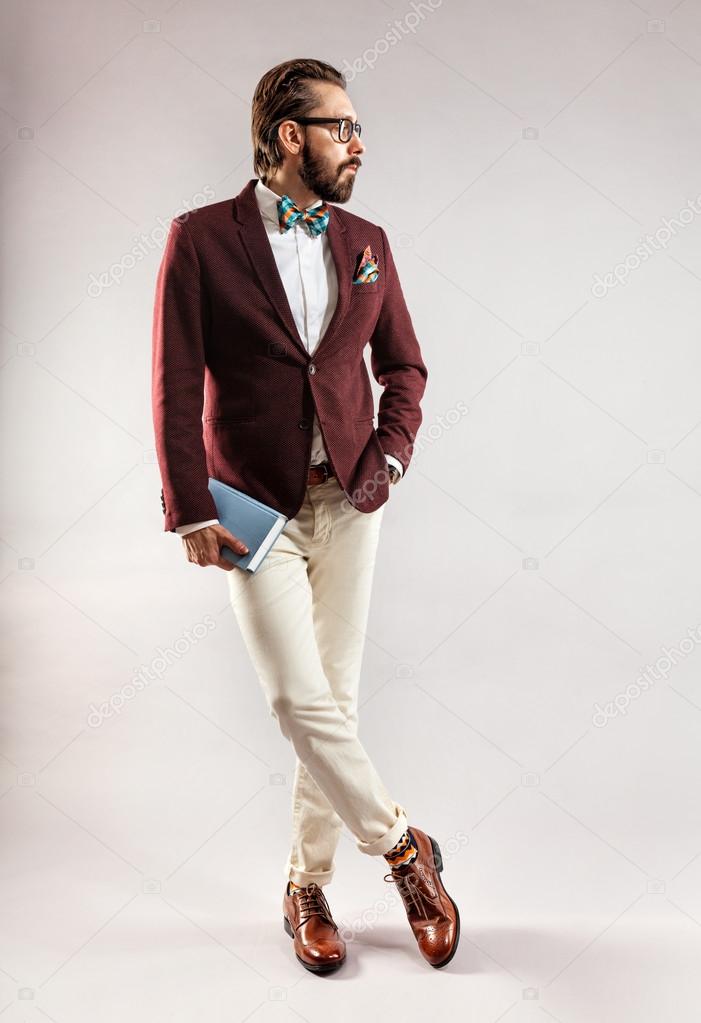 Portrait of a handsome stylish young man with book in hand